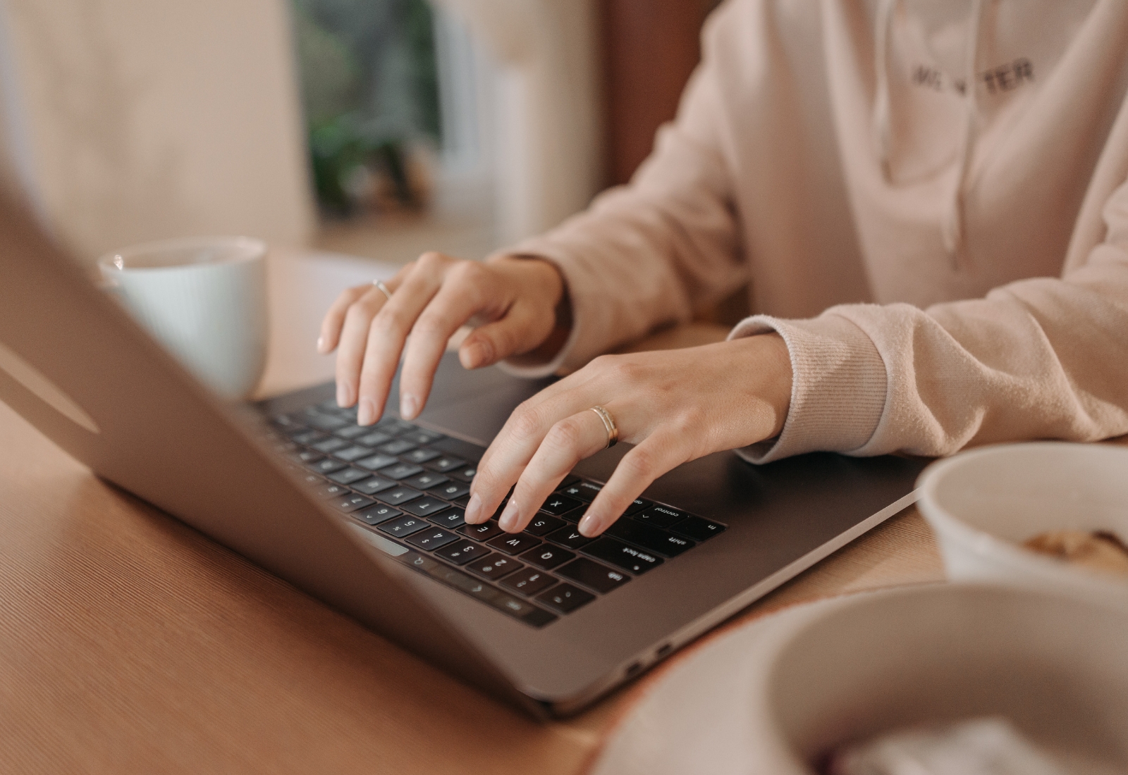 Person tippt auf einem Laptop