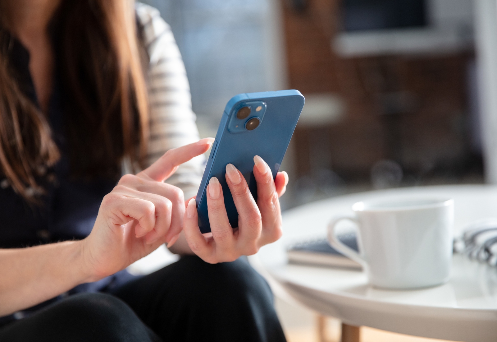 Frau tippt auf blauem Smartphone